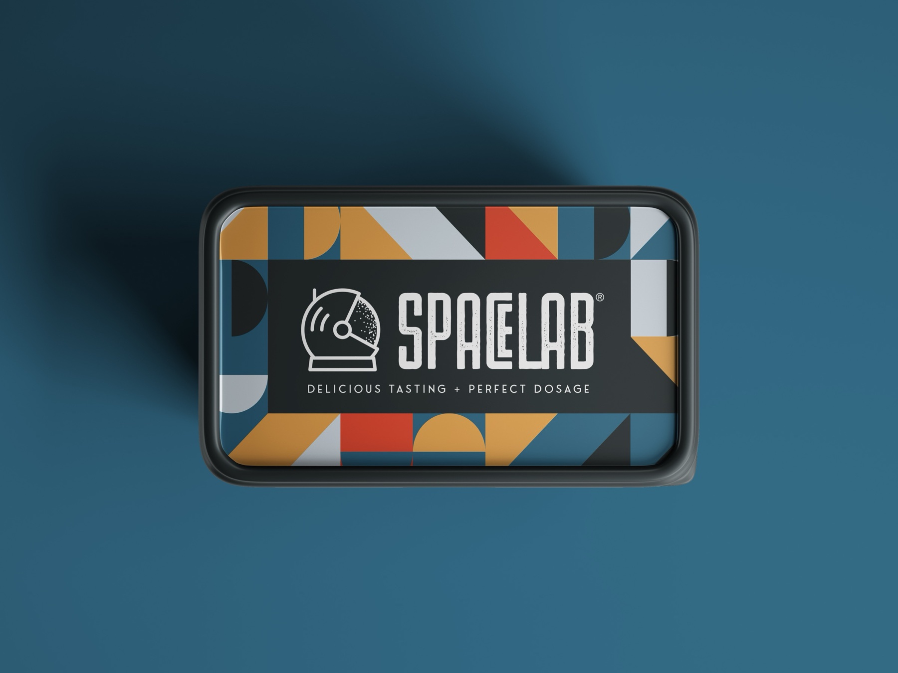 Spacelab tin — geometric pattern lid in ochre, slate, and red with the astronaut-helmet wordmark on a deep blue field